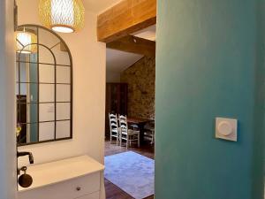 a bathroom with a sink and a mirror and a table at LE CLOS D'ALET in Alet-les-Bains