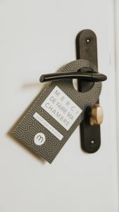 a door handle with a key tag on it at Hôtel De La Marine in Arromanches-les-Bains