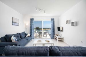 a living room with a blue couch and a table at Villa Xenos Ciel in Tigaki