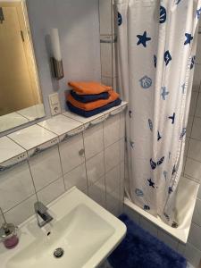 a bathroom with a sink and a shower curtain at Wave in Heiligenhafen