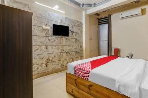 a bedroom with a bed and a tv on a wall at Flagship Hotel Sai Palace Near Gomti Riverfront Park in Chinhat