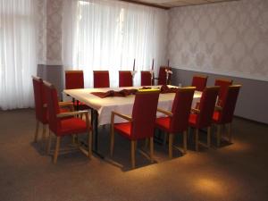 a dining room with a table and red chairs at Holiday Park Orava - Hotel Orava in Dolný Kubín +34 photos