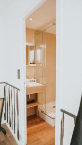 a bathroom with a shower and a sink at Hôtel De La Marine in Arromanches-les-Bains