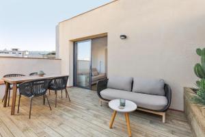 sala de estar con sofá, mesa y sillas en Ola Living Calabria, en Barcelona