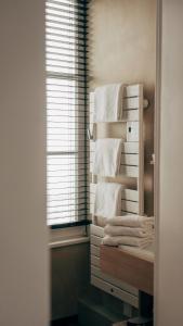 a pile of towels on a towel rack in a bathroom at Hôtel De La Marine in Arromanches-les-Bains