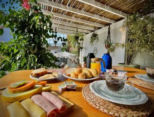 ein Holztisch mit Brot und Essen darauf in der Unterkunft Pousada Maria Parafina Praia do Rosa in Imbituba