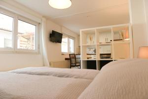 a bedroom with a bed and a desk and window at Ferienwohnung Malou in Tettnang