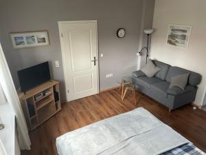 a living room with a couch and a tv at Wave in Heiligenhafen
