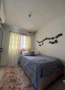 a bedroom with a bed with pictures on the wall at Tizzy Love Apartament 2 in Santo Domingo