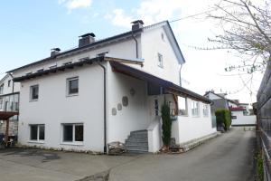 a white house with a black roof at Ferienwohnung Malou in Tettnang
