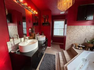 a red bathroom with two sinks and two mirrors at African Zen Oasis in Atlanta