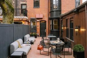 a patio with tables and chairs on a building at No. 284 powered by Sonder in Boston