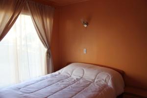 a bedroom with a bed next to a window at Cabañas VyB Empresas facturable y particulares in Cartagena