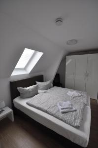 a white bedroom with a bed with a skylight at Ferienwohnung für vier Personen - b57603 in Lütow