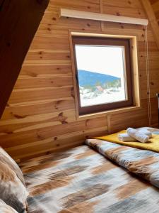 ein Schlafzimmer mit einem Fenster in einem Blockhaus in der Unterkunft Guest House Zabljak in Žabljak