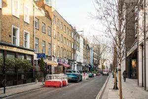 a city street with cars parked on the side of the road at Cosy 1 bedroom home in Fitzrovia in London
