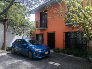 un coche azul estacionado frente a un edificio naranja en Tu Casa en Miahuatlán: Ideal Familias y Grupos en Labor