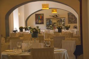 a dining room with white tables and chairs with wine glasses at Hotel Relais VillaGrancassa in San Donato Val di Comino