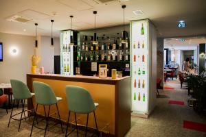 a bar in a restaurant with green chairs at Le Grand Hôtel Grenoble, BW Premier Collection by Best Western in Grenoble