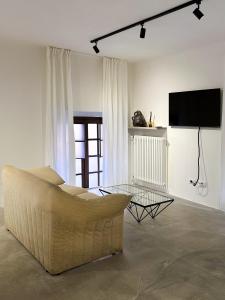 een woonkamer met een bank en een flatscreen-tv bij Mini loft in Reggio Emilia