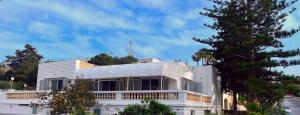 une maison blanche avec un arbre en face dans l'établissement Villa Sunny Side, à Mellieħa