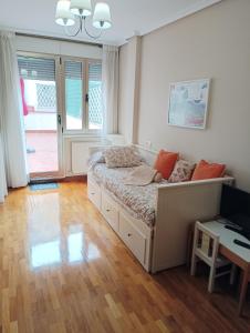 Un dormitorio con una cama y una mesa. en Centro-GASCONA con terraza, garaje y wifi gratuito, en Oviedo