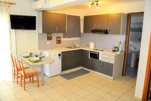 cocina con mesa, fregadero y encimera en Family-friendly studio near the sea., en Dhimínion
