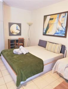 1 dormitorio con 1 cama grande con manta verde en Family-friendly studio near the sea., en Dhimínion