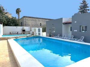 a swimming pool with blue water in a house at Villa Sunny Side in Mellieħa