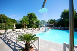 a swimming pool with a palm tree next to a building at Park Hotel Villa Belvedere in Cannobio