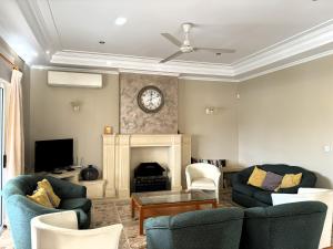 Una sala de estar con dos sillas y una chimenea. en Villa Sunny Side, en Mellieħa