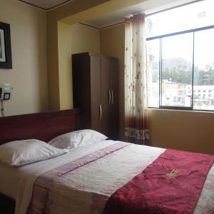 a bedroom with a bed with a large window at Gran Hostal Los Pinos in Cajamarca