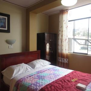 a bedroom with a bed and a window at Gran Hostal Los Pinos in Cajamarca