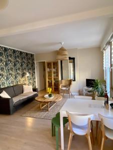 ein Wohnzimmer mit einem Sofa und einem Tisch in der Unterkunft Appartement "Escapade à Malo"pour 4 à 6 personnes 5 mn de la plage in Dunkerque