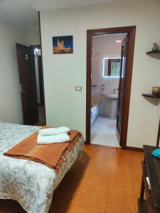 ein Schlafzimmer mit einem Bett und ein Badezimmer mit einer Badewanne in der Unterkunft QUINTA ANDAINA in Sigüeiro