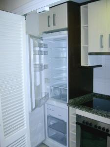 een lege koelkast met de deur open in een keuken bij APARTAMENTO TRIANA in Sevilla