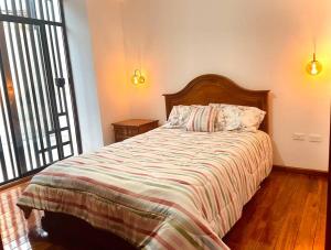 a bedroom with a bed with a striped comforter at Casa de Madera y Mármol in Ambato