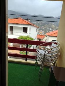 a balcony with a chair and a view of a building at casa na Torre in Machico