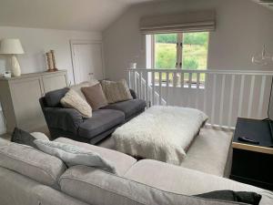 a living room with a couch and a table at Guest Homes - The Teme Loft in Stockton on Teme