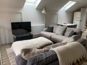a living room with a couch and a tv at Guest Homes - The Teme Loft in Stockton on Teme