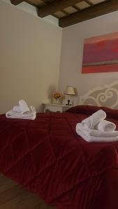 Un dormitorio con una cama roja con toallas. en Le dimore di Gió, en Trapani