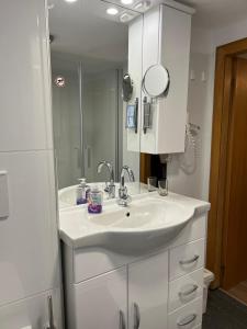 a white bathroom with a sink and a mirror at Eifelerhof hotel Monschau in Monschau