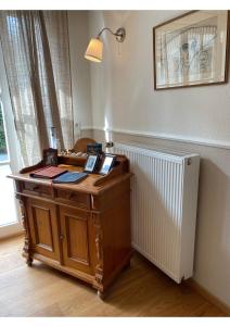 escritorio de madera en una habitación con lámpara en Eine gemütliche Ferienwohnung mit Garten, en Bad Karlshafen