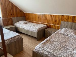 a room with three beds and wooden walls at Homestay in Batumi Дом в Чакви in Chakvi