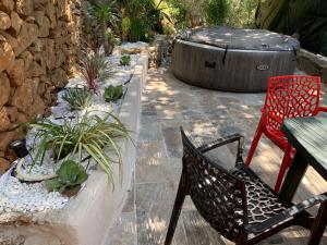 een patio met een tafel en stoelen en een vat bij La Magnanerie in Mialet