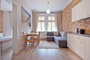 a kitchen and living room with a couch and a table at Apartamenty Leszno in Leszno