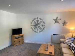 a living room with a couch and a tv and stars on the wall at Captain's Keep - Brixham in Brixham