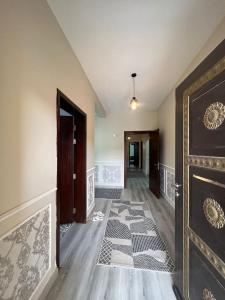 un pasillo vacío con una puerta y una alfombra en فيلا السلطان villa alsoltan en Al Ula