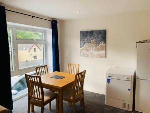 a dining room with a table and chairs and a window at Captain's Keep - Brixham in Brixham