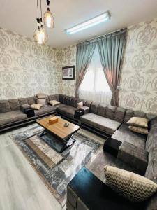 un soggiorno con divano e tavolo di فيلا السلطان villa alsoltan a Al Ula